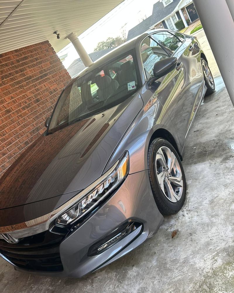 Grey Honda Accord under a carport after a detail, paint reflecting the brick