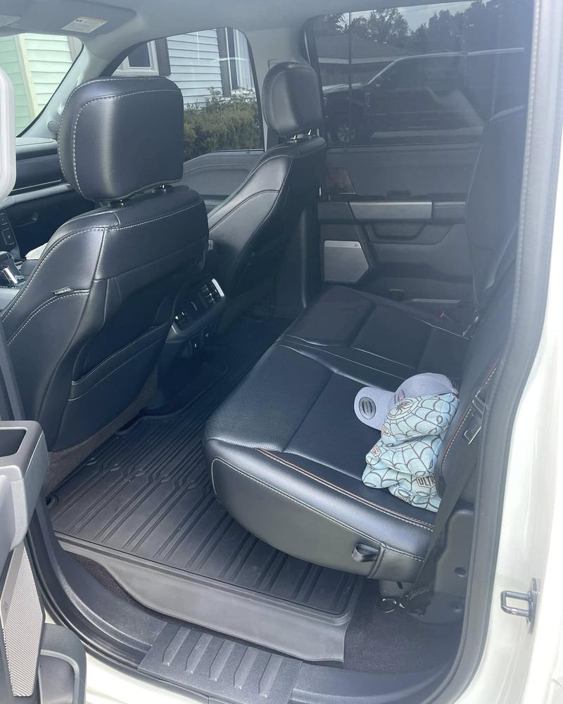 Black leather rear seats of a Ford F-150 after an interior detail, floor mats and seats clean